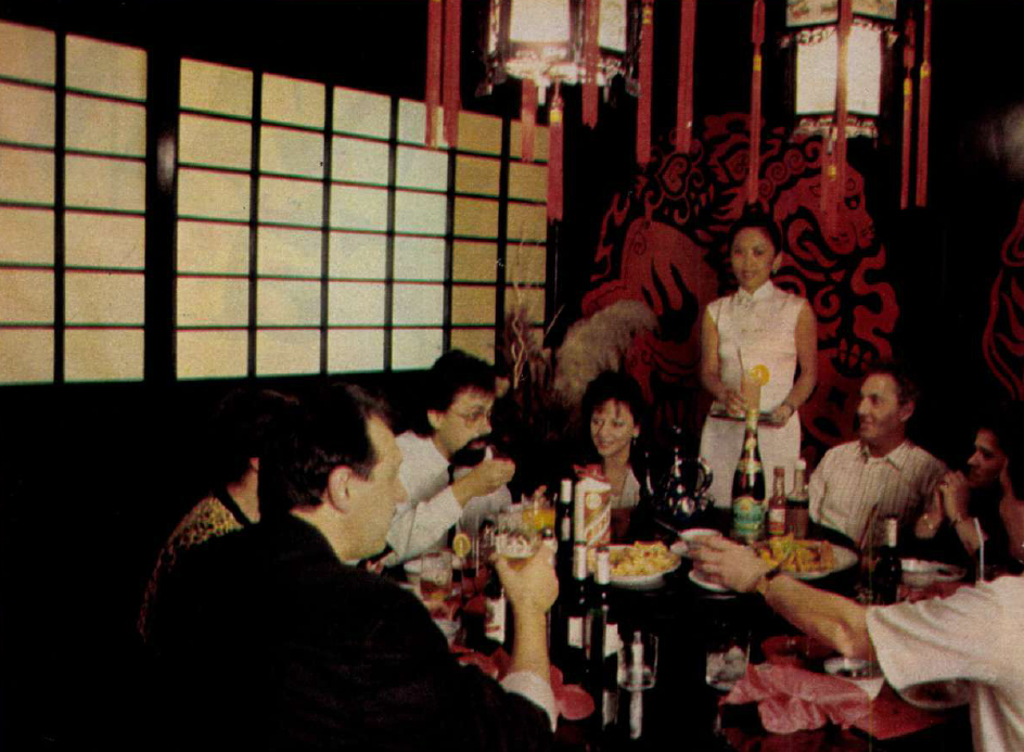 kínai étterem, emberek ülnek asztalnál, asztalon tányérok, palackok