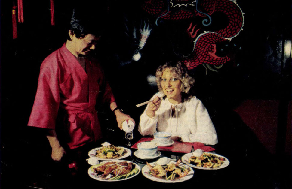 kínai étterem, egy nő ül az asztalnál és eszik, egy kínai ember áll mellette